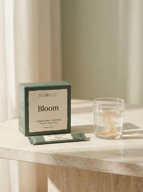 Boîte Floralit Bloom vert sauge et un stick posés près d'un verre d'eau, lumière du matin